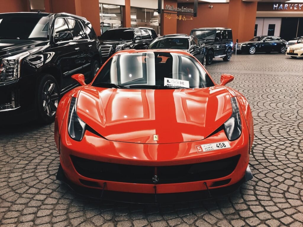 Red Ferrari sports car showcased at Dubai Mall, UAE, symbolizing luxury and elegance.